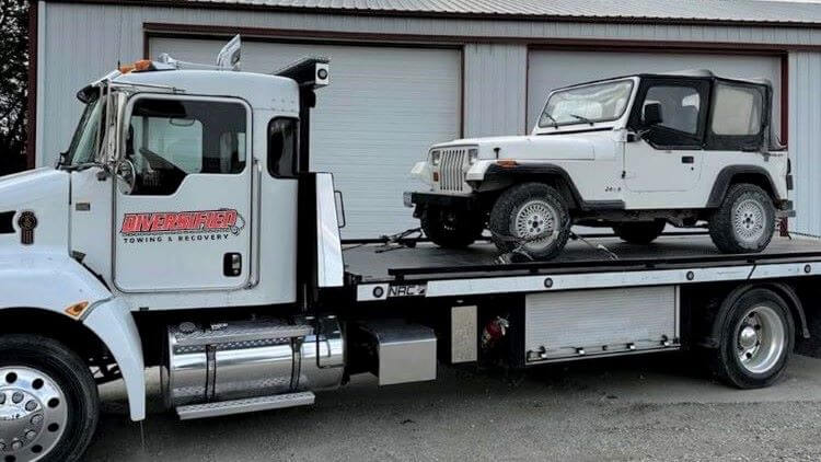 Jeep on flatbed tow truck