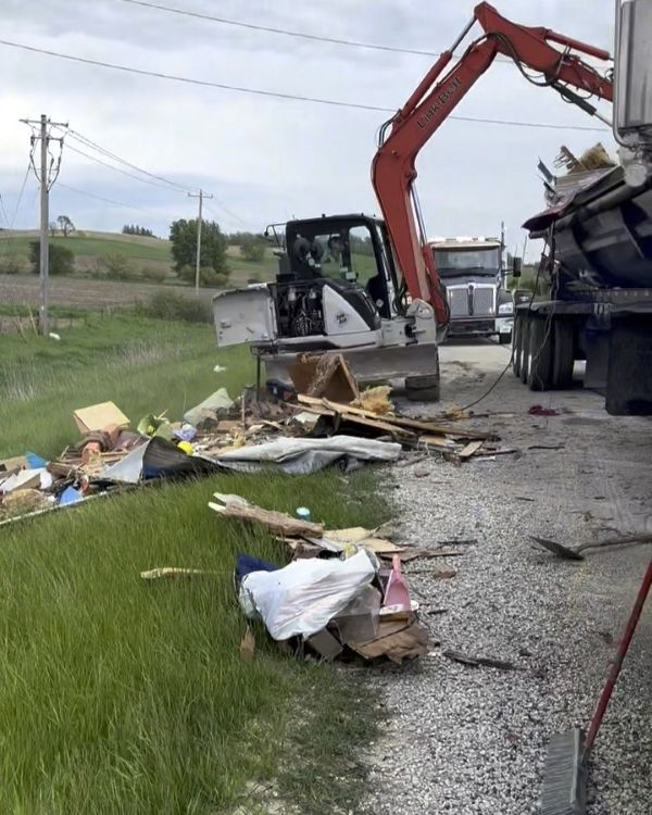 Machine removing accident debris from side of road