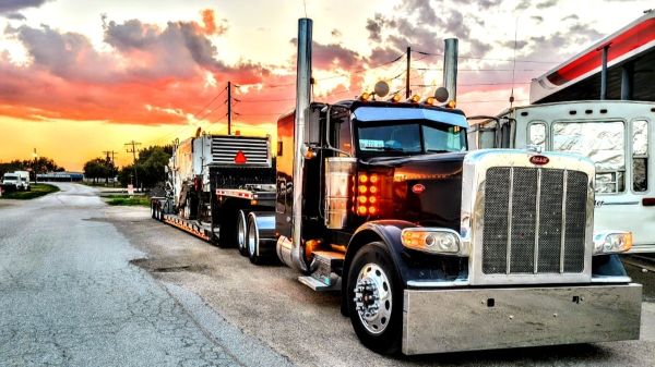 Heavy duty truck with large machine on trailer