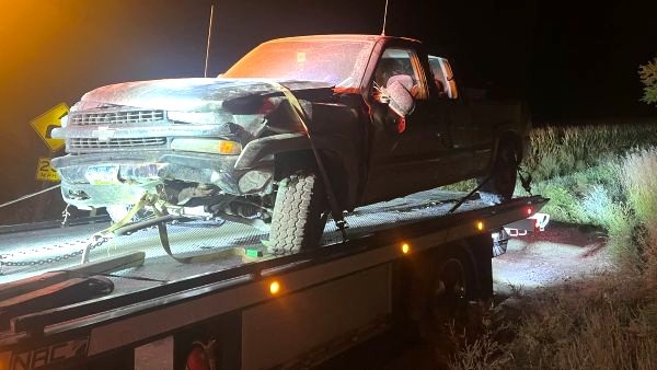 wrecked vehicle on flatbed at night