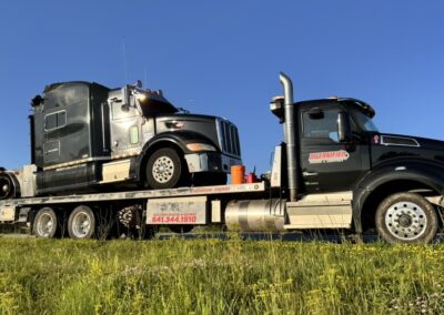 Dmaged semi on flat bed tow truck