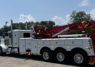 Large white tow truck with red cranes