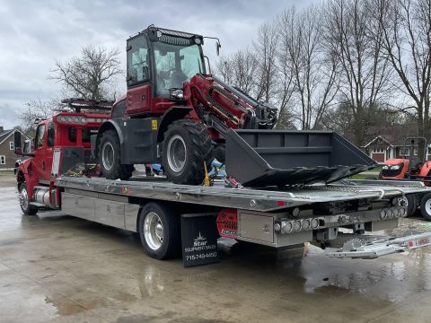 Red tractor on flatbed tow truck