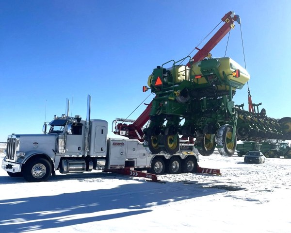 Farm impliment being lifed by rotator tow truck